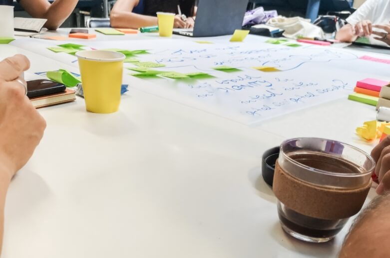 A team meeting with coffee and sticky notes on the table