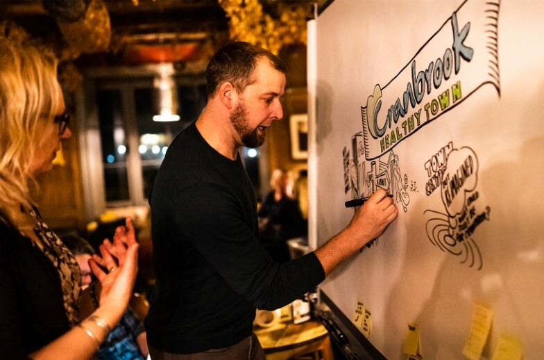 An illustrator drawing on whiteboard