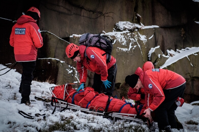 Mountain Rescue helping an injured person in snowy conditions