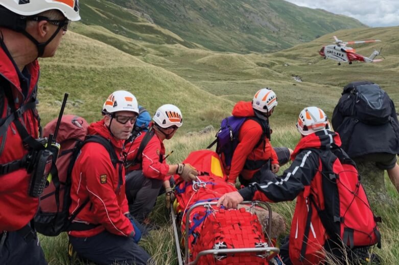 Mountain rescue in a mountainous area helping an injured person on a stretcher