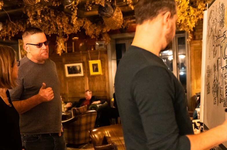 People gathering around a whiteboard creating illustrations